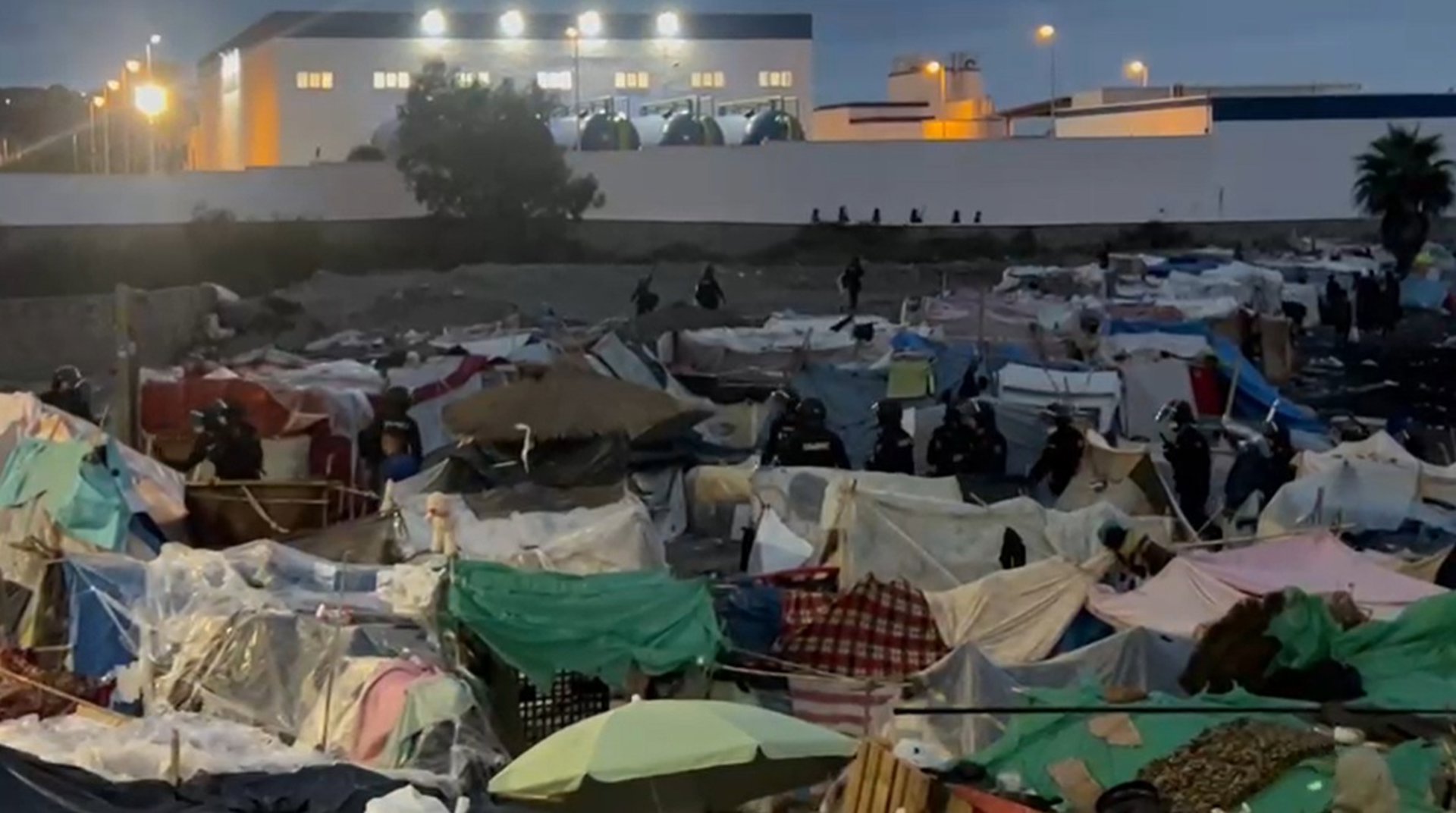 La Policía Nacional inicia el traslado de centenares de migrantes de la playa de Benítez hacia el CATE de Ceuta